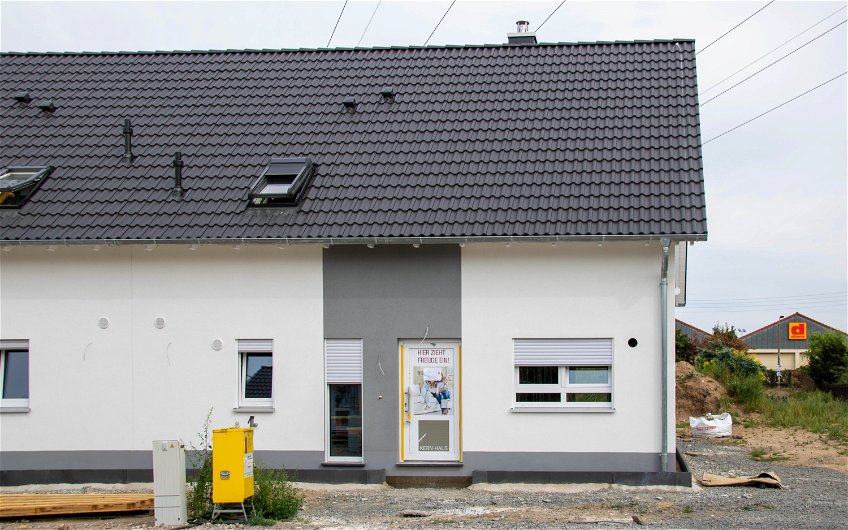 Kern-Haus Doppelhaushälfte mit Außenputz und grauem Streifen in Leipzig