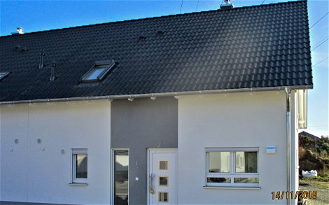 Hauseingangsseite des Kern-Haus Doppelhaus mit grauem Putz in Leipzig