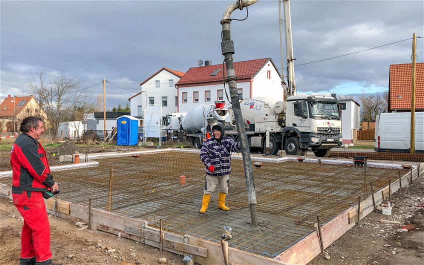 Handwerker beim Betonieren der Bodenplatte für Kern-Haus in Göbschelwitz