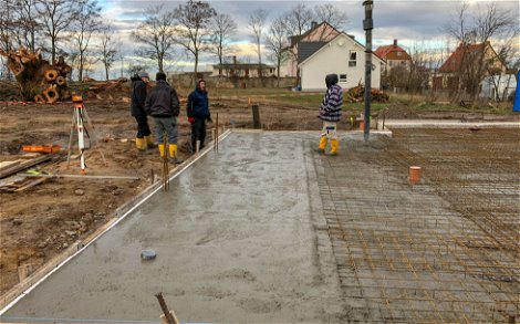 Handwerker mit betonierter Bodenplatte für Kern-Haus in Göbschelwitz
