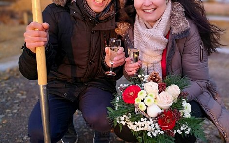 Bauherren mit Spaten und Blumen bei Grundsteinlegung für Kern-Haus Stadtvilla in Kitzscher