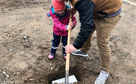 Bauherr mit Kind bei Vergraben der Grundsteinkassette für Kern-Haus Bungalow in Mügeln