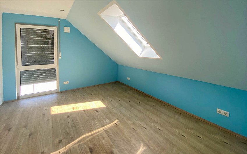 Schlafzimmer mit blauem Anstrich in Kern-Haus Aura in Großkugel