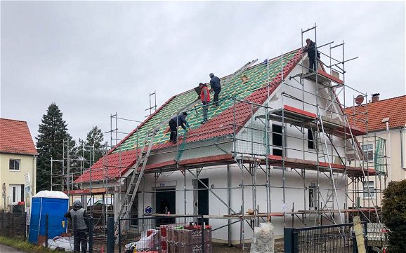 Eindecken des Daches mit roten Dachschindeln für Kern-Haus in Kleinzschocher