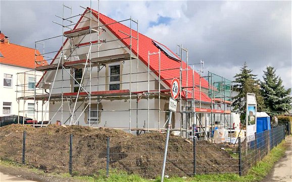 Satteldach Rohbau von Kern-Haus mit rotem Dach und eingebauten Fenstern in Kleinzschocher