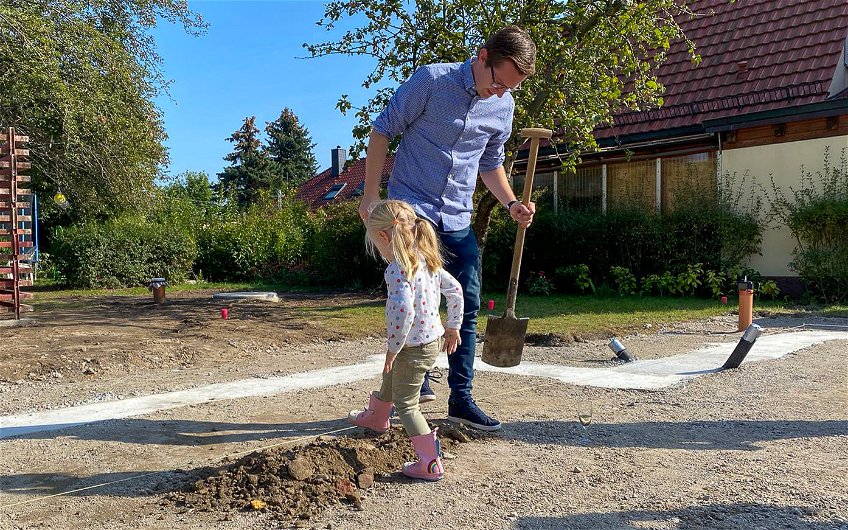 Tochter der Bauherren hilft beim Festtreten bei Grundsteinlegung für Kern-Haus in Wiederitzsch
