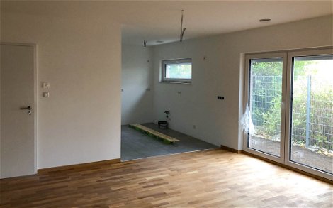 Wohnbereich gefliest mit Holzfliesen und Kochecke in Kern-Haus Jara in Engelsdorf