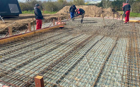 Gießen des Beton in armierte Bodenplatte für Kern-Haus Allea in Eilenburg