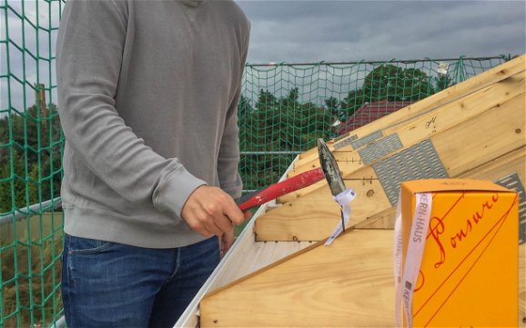 Bauherr beim Einschlagen des letzten Nagels in den Dachstuhl der Kern-Haus Stadtvilla in Markranstädt