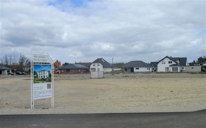 Grundstück mit Bauschild vor Baubeginn des Kern-Haus Signus in Sandersdorf
