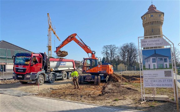 Tiefbauarbeiten auf Grundstück mit Bauschild für Kern-Haus Stadtvilla in Pegau