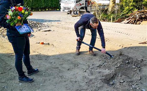Bauherrin beobachtet Bauherr bei Grundsteinlegung für Kern-HAus Jara in Leipzig