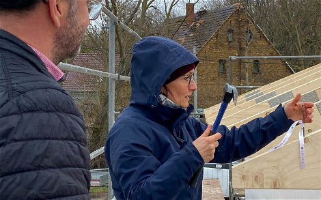 Bauherrin beim Einschlagen des Nages für Kern-Haus Bungalow in Brodau
