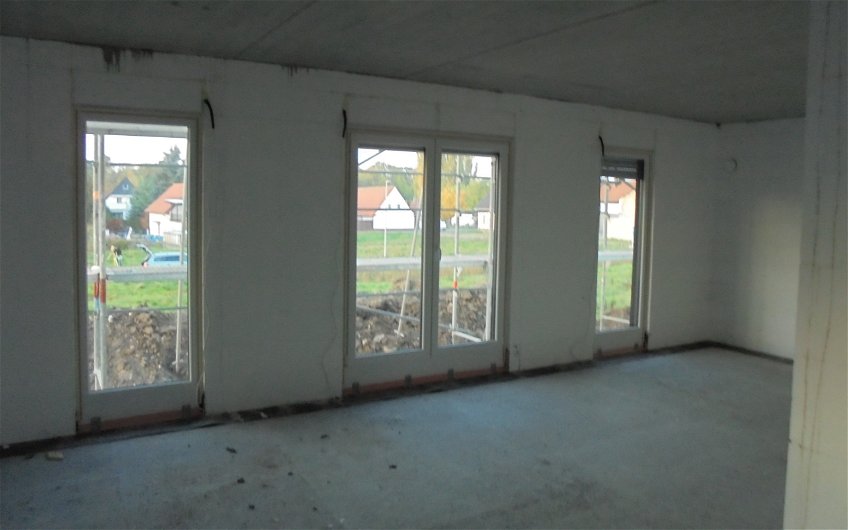 Wohn- und Essbereich des Kern-Hauses Komfort in Obrigheim im Rohbauzustand mit Blick in den Garten