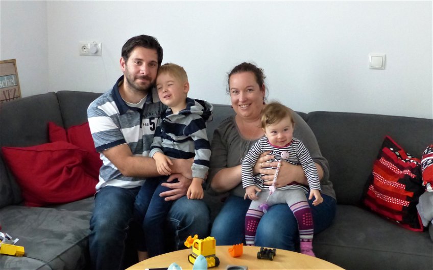 Baufamilie auf der Couch im Wohnzimmer des Kern-Hauses Komfort in Linkenheim-Hochstetten