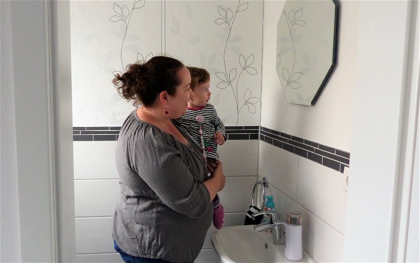 Bauherrin mit Tochter im Gäste-WC des Familienhauses Komfort in Linkenheim-Hochstetten