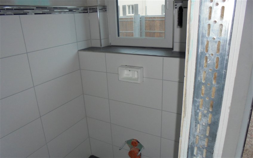 Fliesenarbeiten im Gäste-WC des individuell geplanten Einfamilienhauses Komfort von Kern-Haus in Herxheim