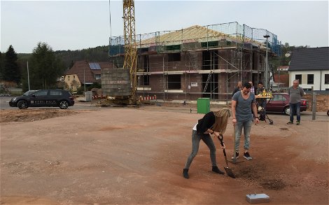 Bauherrin mit Spaten bei der Grundsteinlegung für die Kern-Haus-Stadtvilla Signus in Otterberg