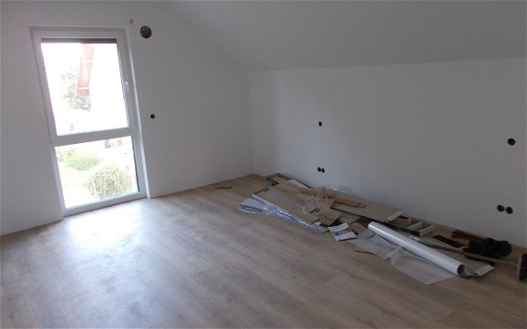 Zimmer im Obergeschoss mit verlegtem Boden im Familienhaus Loop Classic in Freisbach