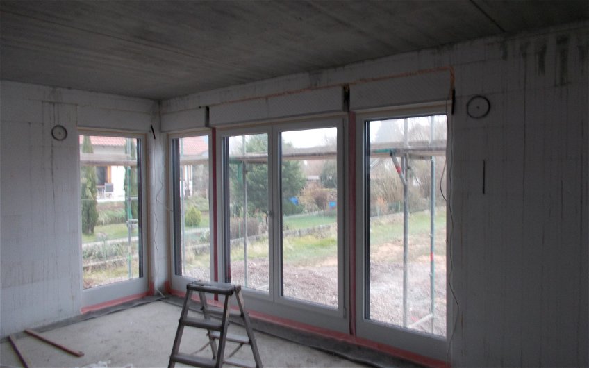 Fensterfront mit Terrassenzugang im Wohnzimmer des individuell geplanten Einfamilienhauses Loop Classic von Kern-Haus in Freisbach