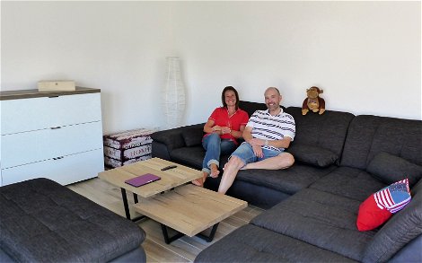 Bauherren auf der Couch im Wohnbereich des individuell geplanten Einfamilienhauses Luna von Kern-Haus in Dettenheim