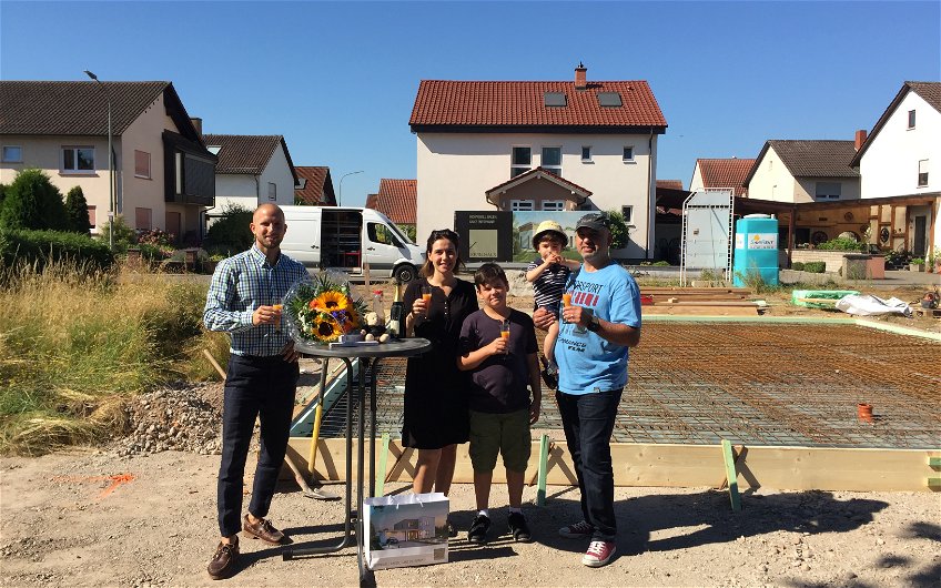 Bauherren und Verkaufsberater bei der Grundsteinlegung für das individuell geplante Einfamilienhaus Komfort von Kern-Haus in Neupotz