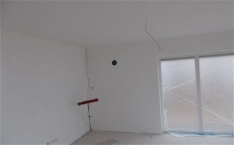 Wohnzimmer des frei geplanten Einfamilienhauses von Kern-Haus in Römerberg mit tapezierter Decke und gestrichenen Wänden
