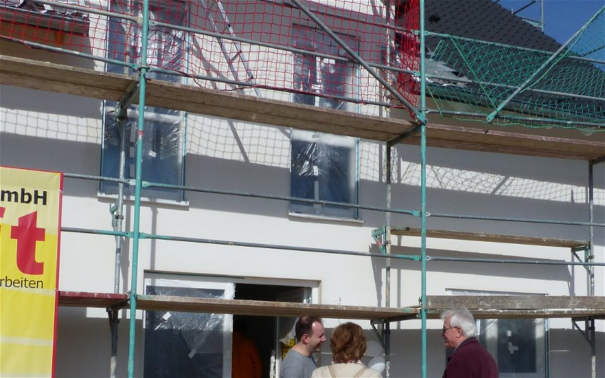 Vertriebsleiter Steffen Müller mit Interessenten vor dem Haus beim Rohbaufest im individuell geplanten Einfamilienhaus von Kern-Haus in Römerberg