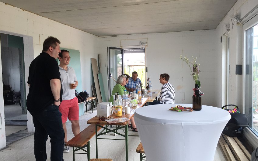 Interessent mit Verkaufsberater im Gespräch beim Rohbaufest im individuell geplanten Einfamilienhaus Luna von Kern-Haus in Bruchsal