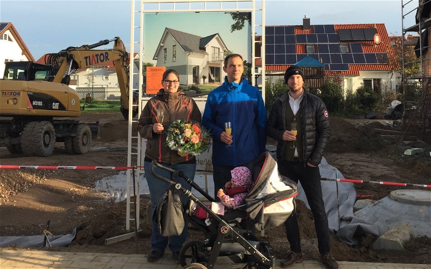 Baufamilie mit Verkaufsberater Bernd Laatz bei der Grundsteinlegung für das frei geplante Einfamilienhaus von Kern-Haus in Römerberg