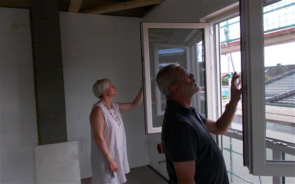 Bauherren beim Inspizieren der eingebauten Fenster des frei geplanten Einfamilienhauses von Kern-Haus in Jockgrim