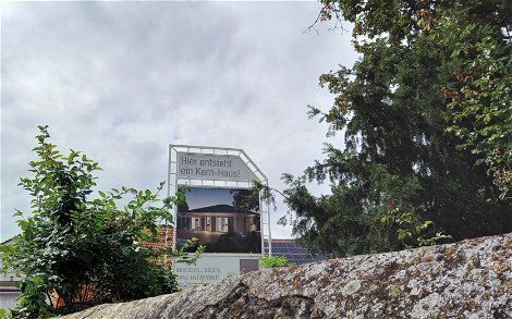 Bauschild auf dem Grundstück für den frei geplanten Bungalow von Kern-Haus in Bockenheim