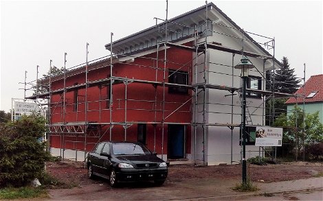 Das Pultdachhaus in der Straßenansicht mit farblich hervorgehobener Fassade.