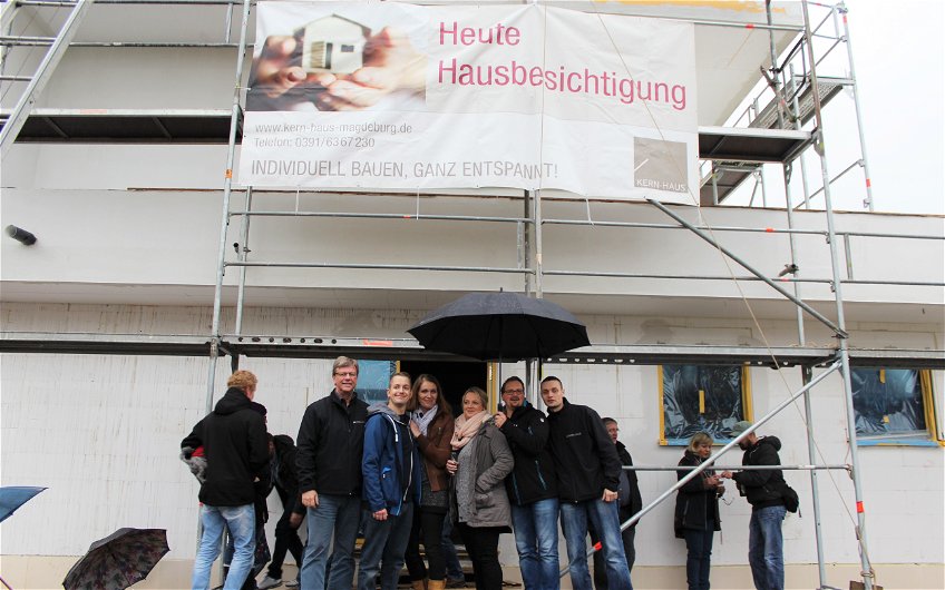 Kern-Haus-Verkaufsleiter Joachim Schmahl (links im Bild) und Mitarbeiter für Planung und Service Sebastian Rabach (rechts im Bild) gemeinsam mit beiden Bauherrenfamilien (Mitte) zu ihren Rohbaufesten.