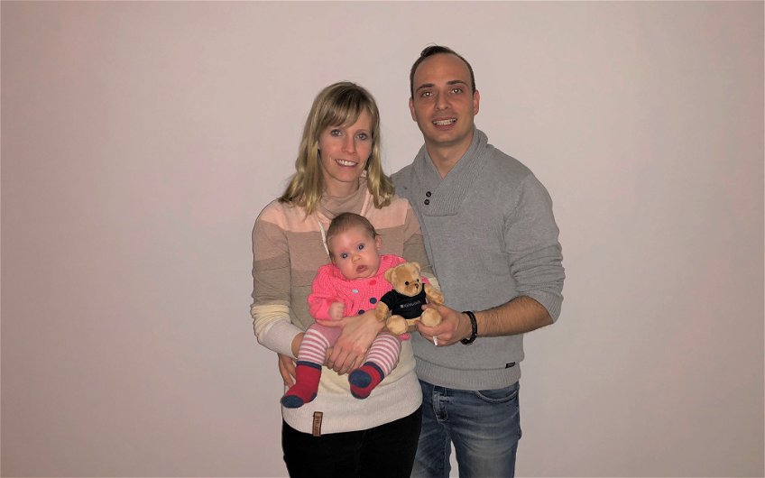 Eltern mit Baby im Arm im neuen Zuhause von Kern-Haus in Magdeburg