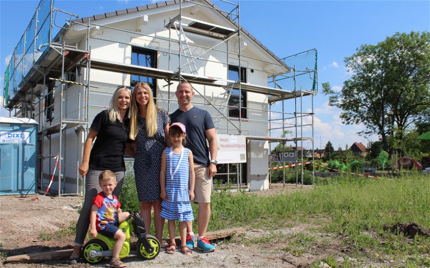Bauherren mit Projektmanagerin vorm Kern-Haus in Barleben