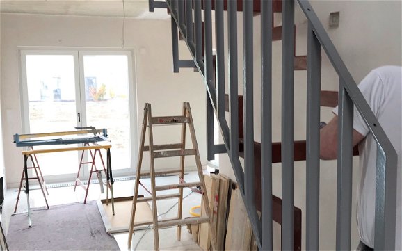 Die Stahlkonstruktion der Treppe wird in einem modernen Grauton gestrichen.