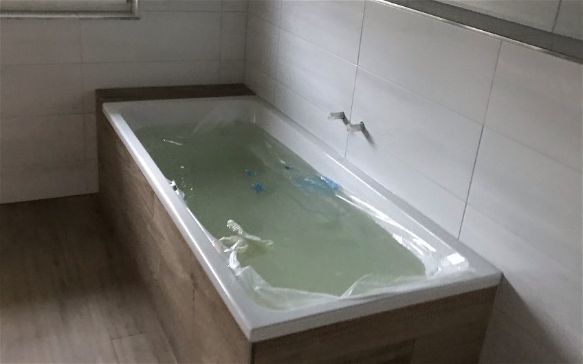 Badezimmer mit Badewanne und Holzfliesen
