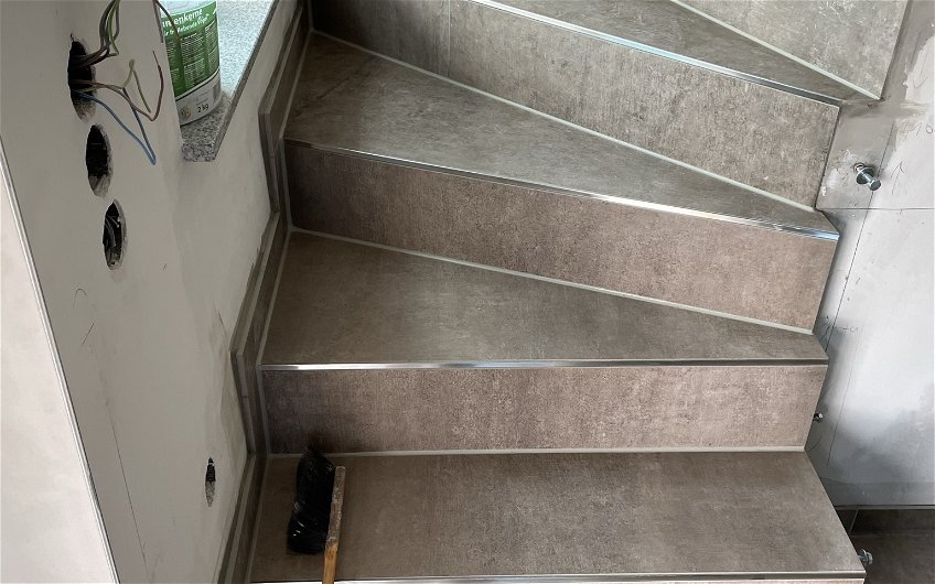 Fliesenabschlussprofile schützen die Kanten der gefliesten Treppe.