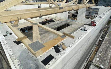 Die Holzkonstruktion des Dachstuhls wird auf das Obergeschoss aufgelegt.