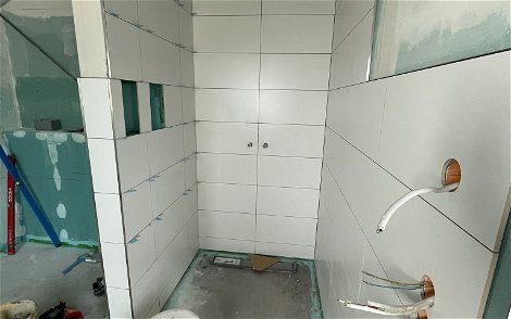 Im Duschbereich werden die Wände gefliest.