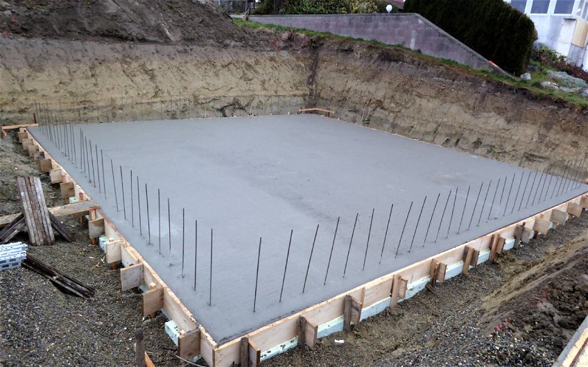 Gegossene Fundamentplatte aus Beton mit Holzschalung und Bewahrungseisen.