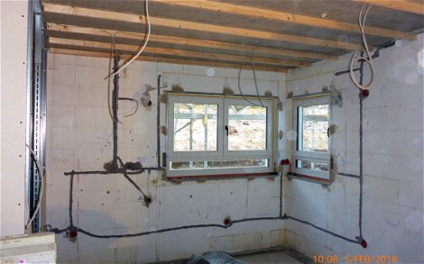 Küchenraum mit verlegten Elektrokleitungen in Wandschlitzen und auf der Rohbaudecke.