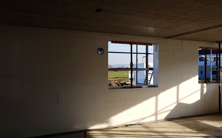 Blick auf Wand aus DuoTherm Compound-Elementen mit zwei Fensteröffnungen und Loch für die Lüftungsanlage.