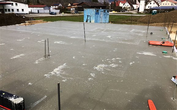 Bodenplatte aus Beton mit verschiedenen Rohren und Stangen.
