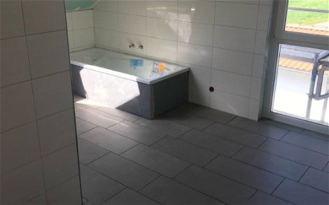 Fliesenarbeiten im Badezimmer des frei geplanten Familienhauses von Kern-Haus in Heiligenberg