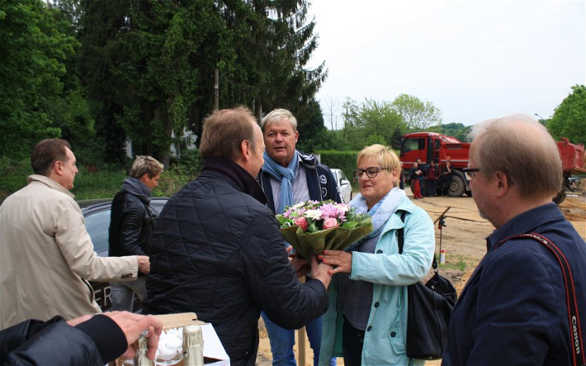 Der Kern-Haus Rhein-Ruhr Geschäftsführer Axel Kaltenbach überreicht der Bauherrin Blumen.