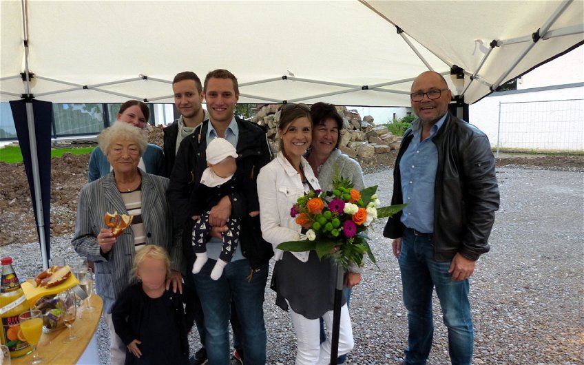 Gruppenbild mit Bauherren und Familie sowie mit Verkaufsberater Andreas Huss.