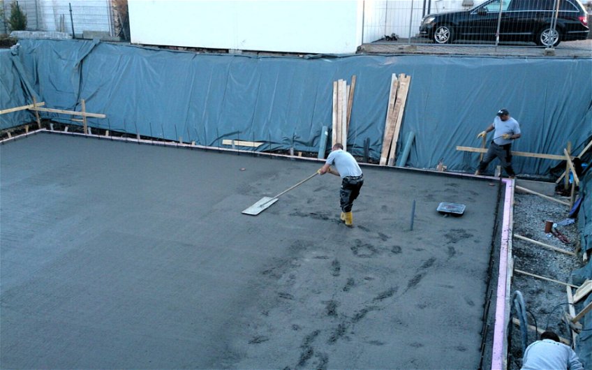 Handwerker beim Glätten der Fundamentoberfläche aus Beton.