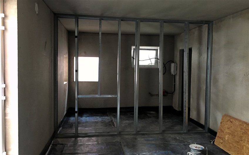 Raum in Rohbauzustand mit offenem Ständerwerk aus Metall für Innenwand.
